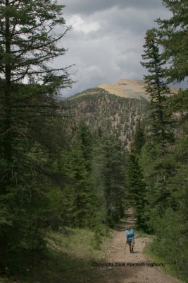 The trail back down, with a view of stormclouds and mine tailings.
